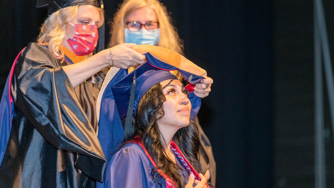 Ariel Alonzo is hooded during the College of Nursing’s August commencement at Centennial Hall.