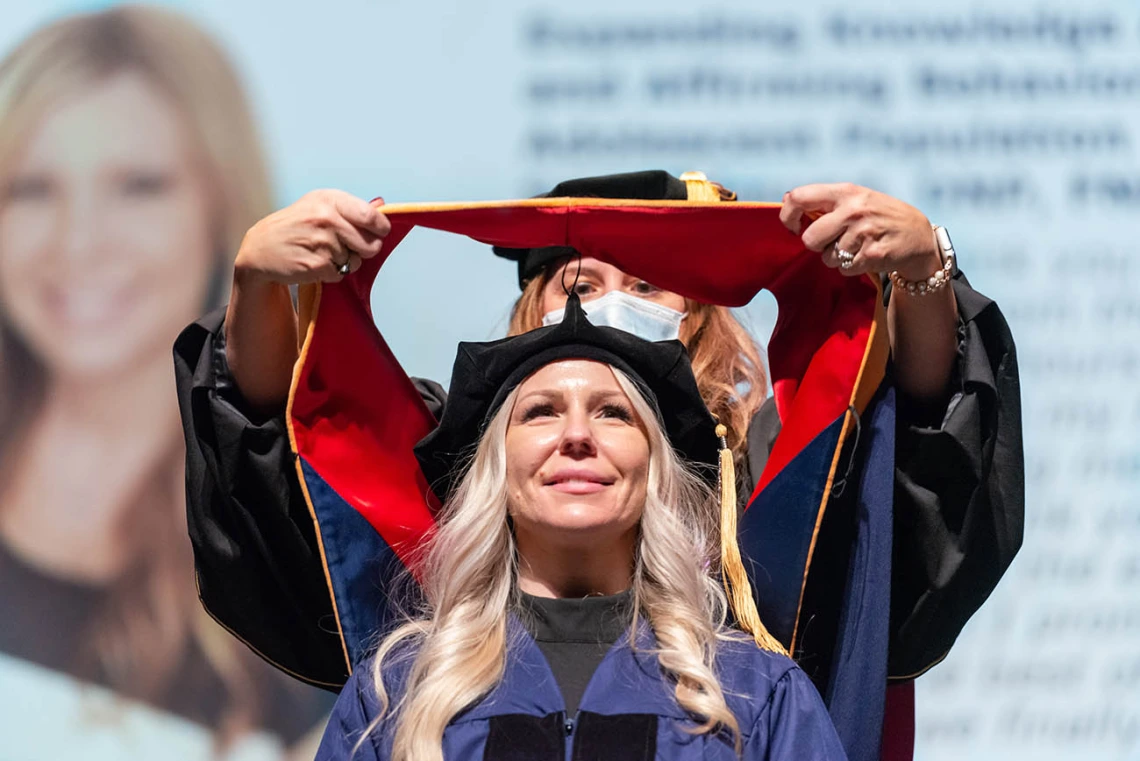 Amanda Keenhold, who received a Doctor of Nursing Practice, is hooded during the College of Nursing fall convocation at Centennial Hall.