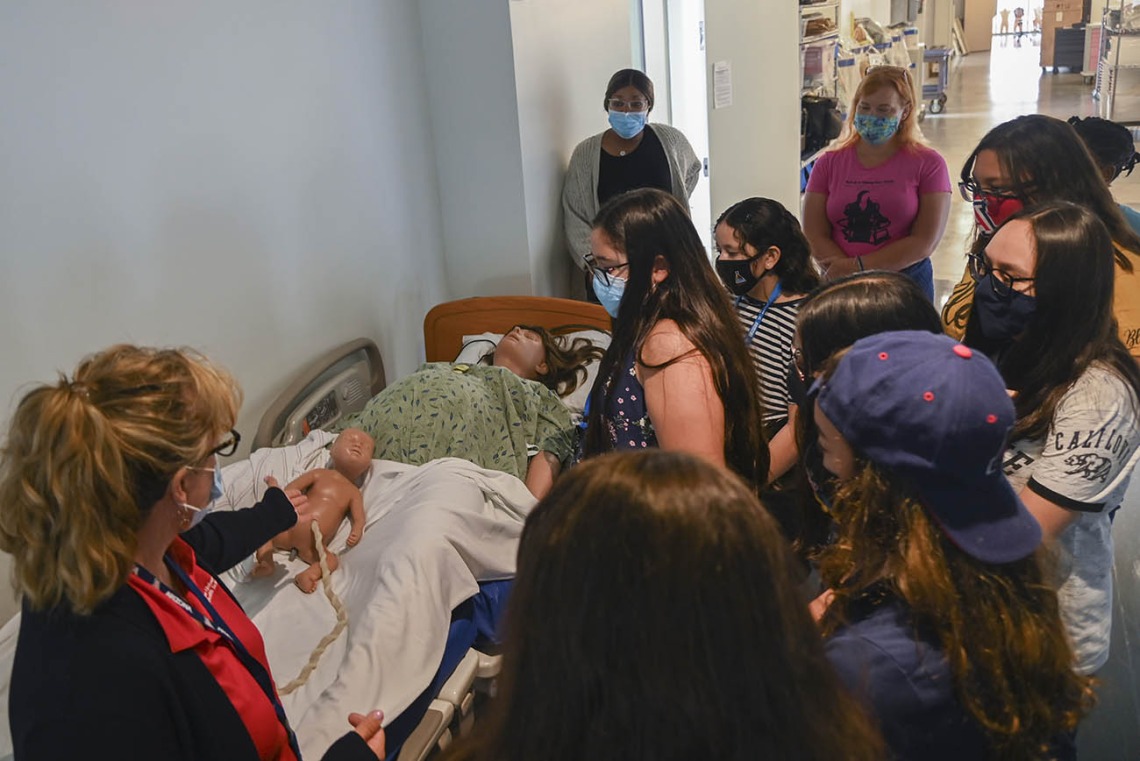 Deana Ann Smith, RN, health care simulation educator for ASTEC, left, shows ACES campers the labor and delivery patient simulator during their tour.