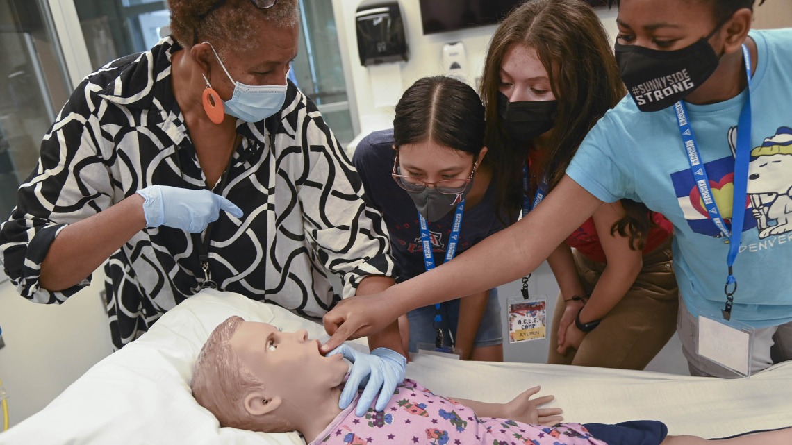 Southern Arizona Research, Science and Engineering Foundation (SARSEF) campers practice a procedure on Hal, the pediatric patient simulator, as explained to them by ASTEC’s Rochelle Marshall. The girls, all part of the Applied Career Exploration in Science (ACES) camp were, from left, Jeanette Mendoza, Ayleen Cruz and Victoria Vigbedorh.
