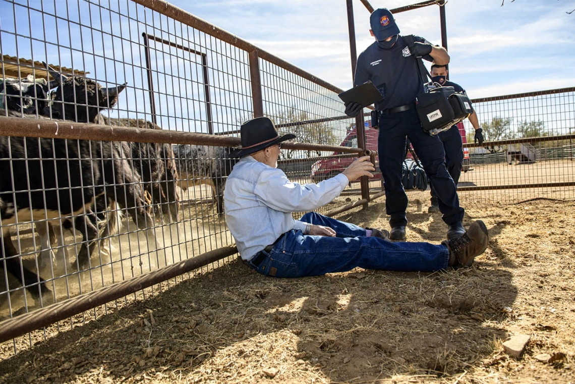 Rio Rico emergency medical technicians set up field equipment to assist rancher Leon Keller with his injury. (Note: This was a simulated accident scene for demonstration purposes.)