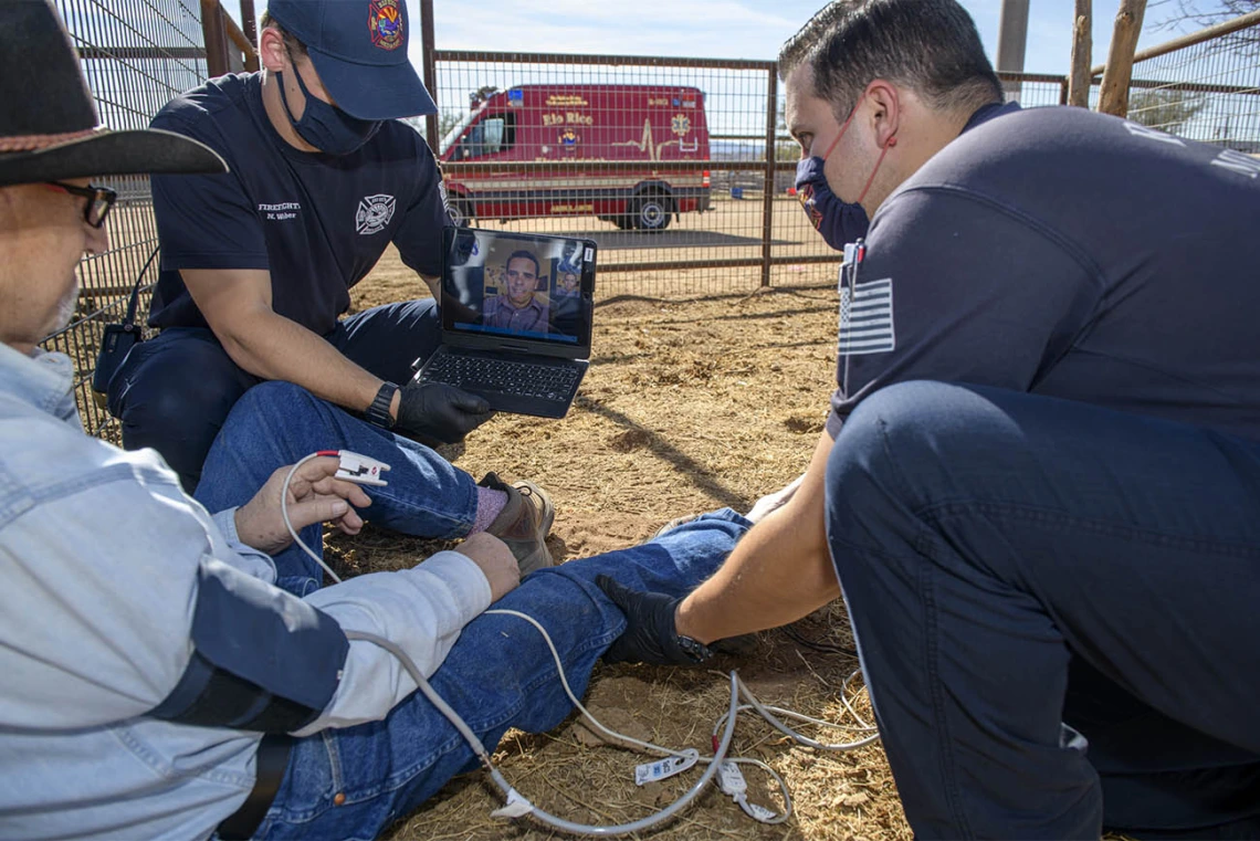 Tucson emergency department physician Dr. Joshua Gaither consults with Weber and Saez about treatment options using the AzREADI telehealth technology. (Note: This was a simulated accident scene for demonstration purposes.)