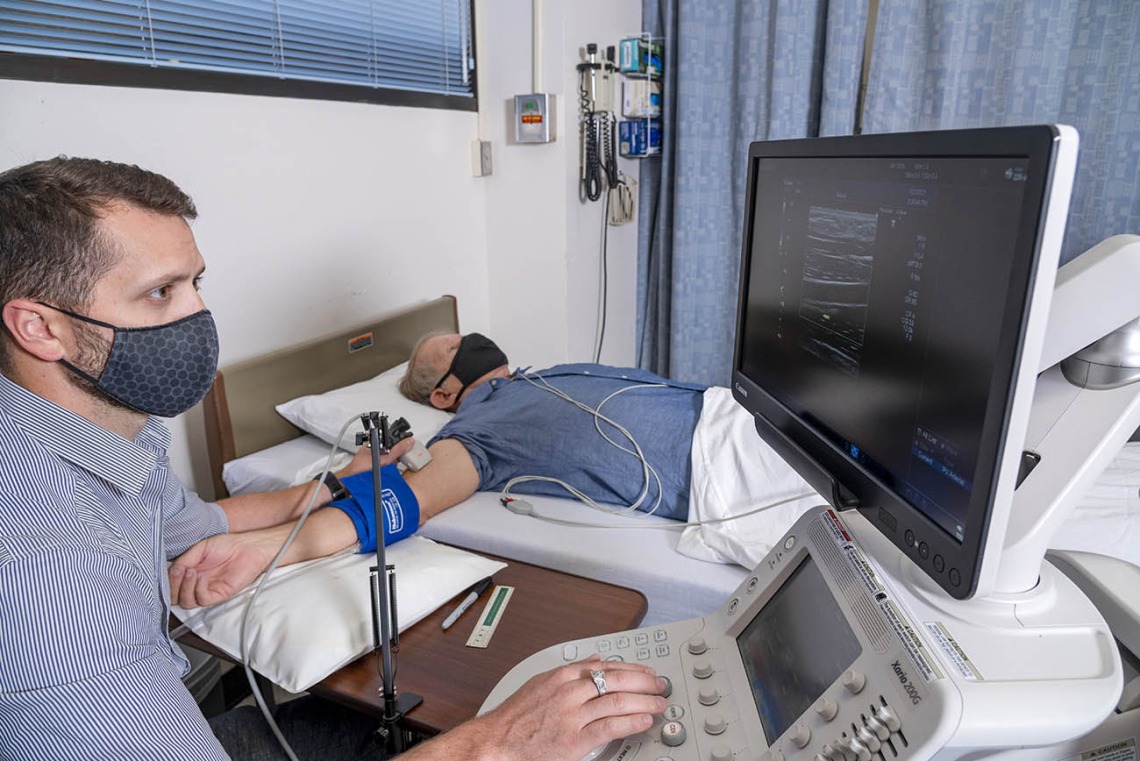 Dallin Tavoian, PhD, uses an ultrasound probe to obtain an image of an artery in the participant's upper arm. The flow-mediated dilation procedure assesses the artery's response to a change in blood flow, an important marker of cardiovascular health.