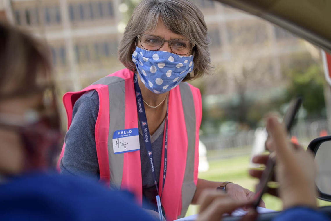 Andrea Fisher, College of Nursing associate vice president for development, confirms vaccination appointments before drivers pull up to the vaccine distribution site.