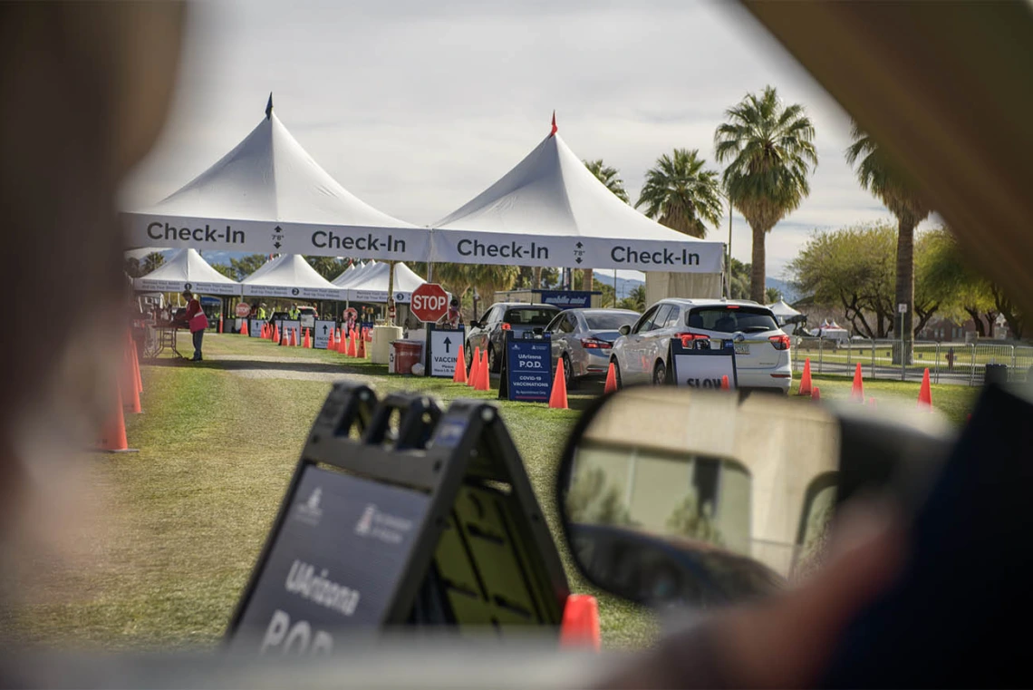 A line of cars approaches the check-in point after their vaccination appointments are confirmed.