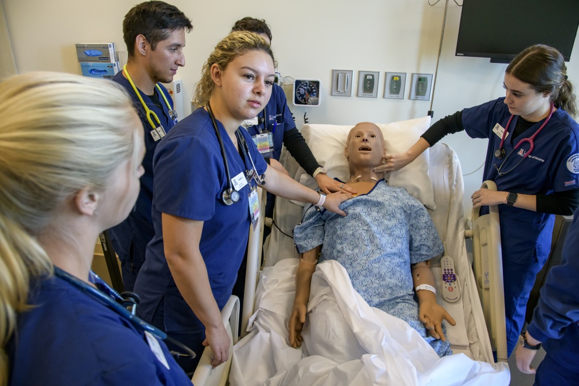 Students examining a patient simulation.
