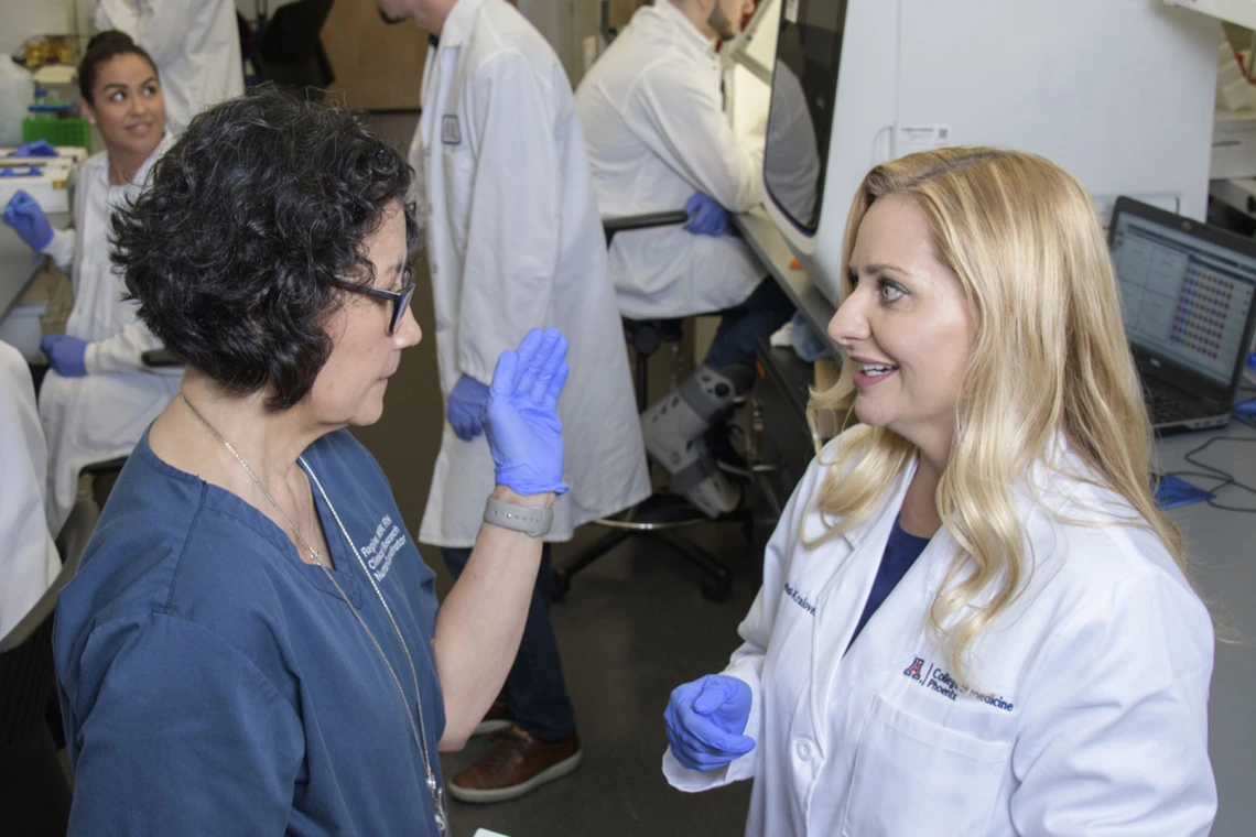 Two female researchers having a discussion in lab.