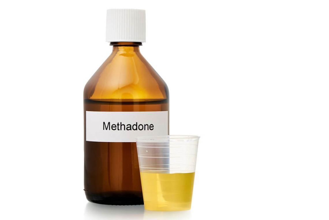 brown bottle labeled methadone with small dose cup
