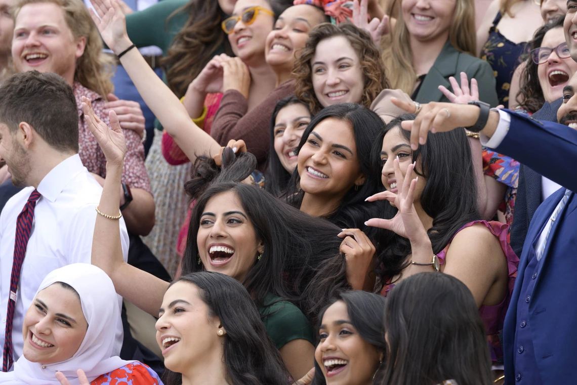 Dozens of fourth-year medical students from the University of Arizona College of Medicine – Tucson wave, smile and show the hand sign for “Wildcats.” 