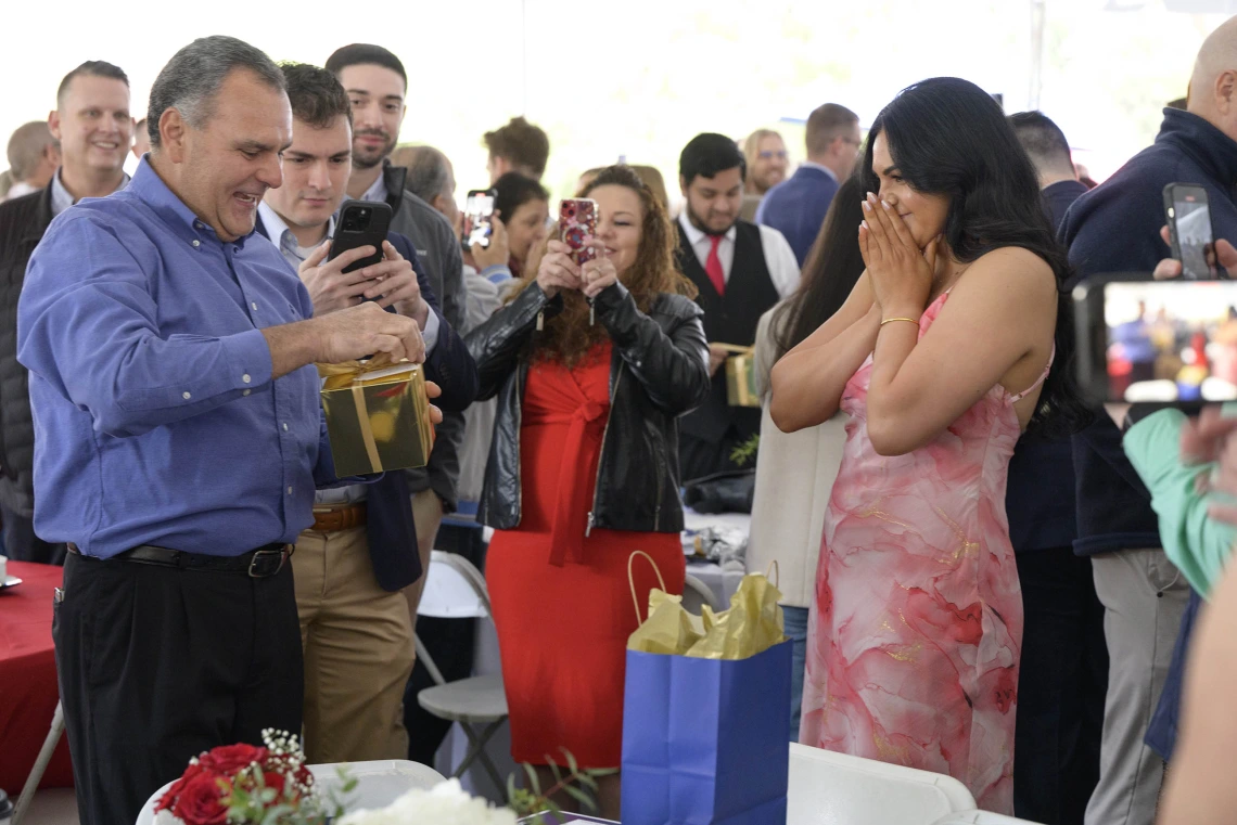 A man reads a sheet of paper as a young woman covers her mouth in anticipation at the University of Arizona College of Medicine – Tucson Match Day celebration. 