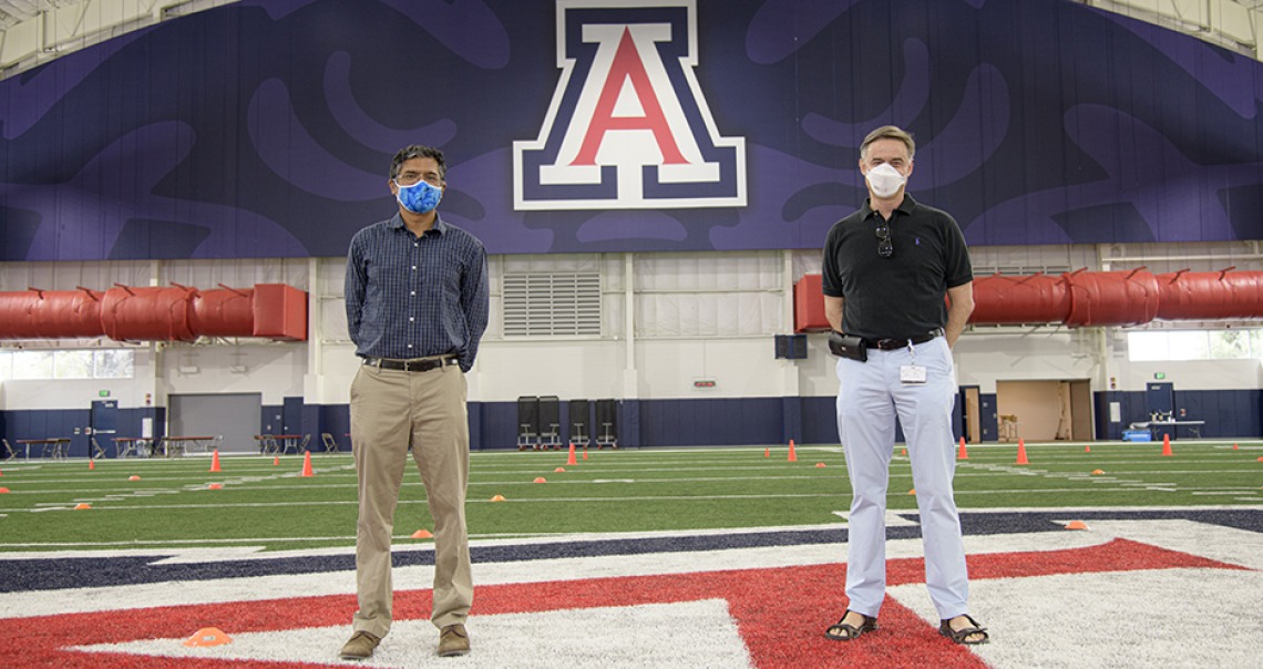 two masked men stand in football arena