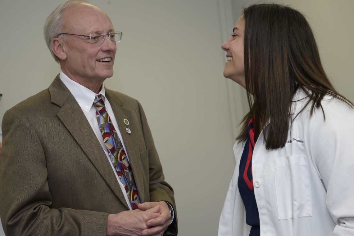 University of Arizona College of Pharmacy Dean Rick Schnellmann smiles as he talks with Ashley Campbell, a professor.   