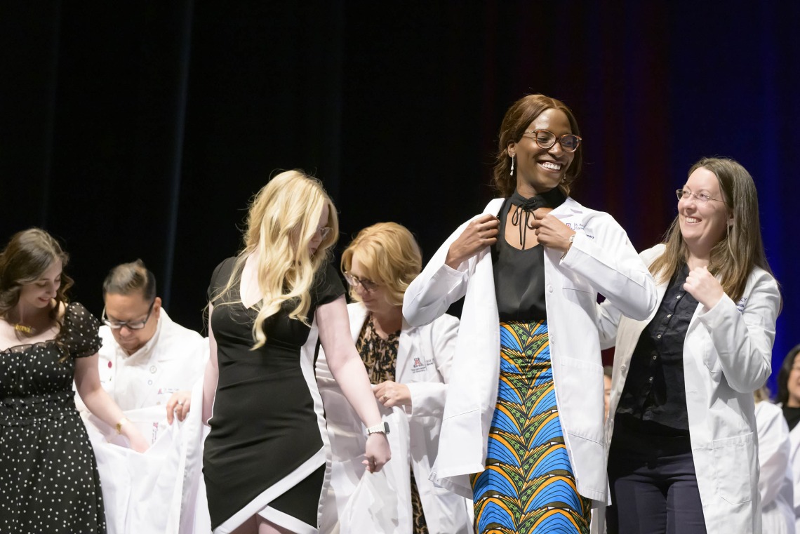 Several pharmacy students put on their white coats with the help of University of Arizona R. Ken Coit College of Pharmacy professors. 