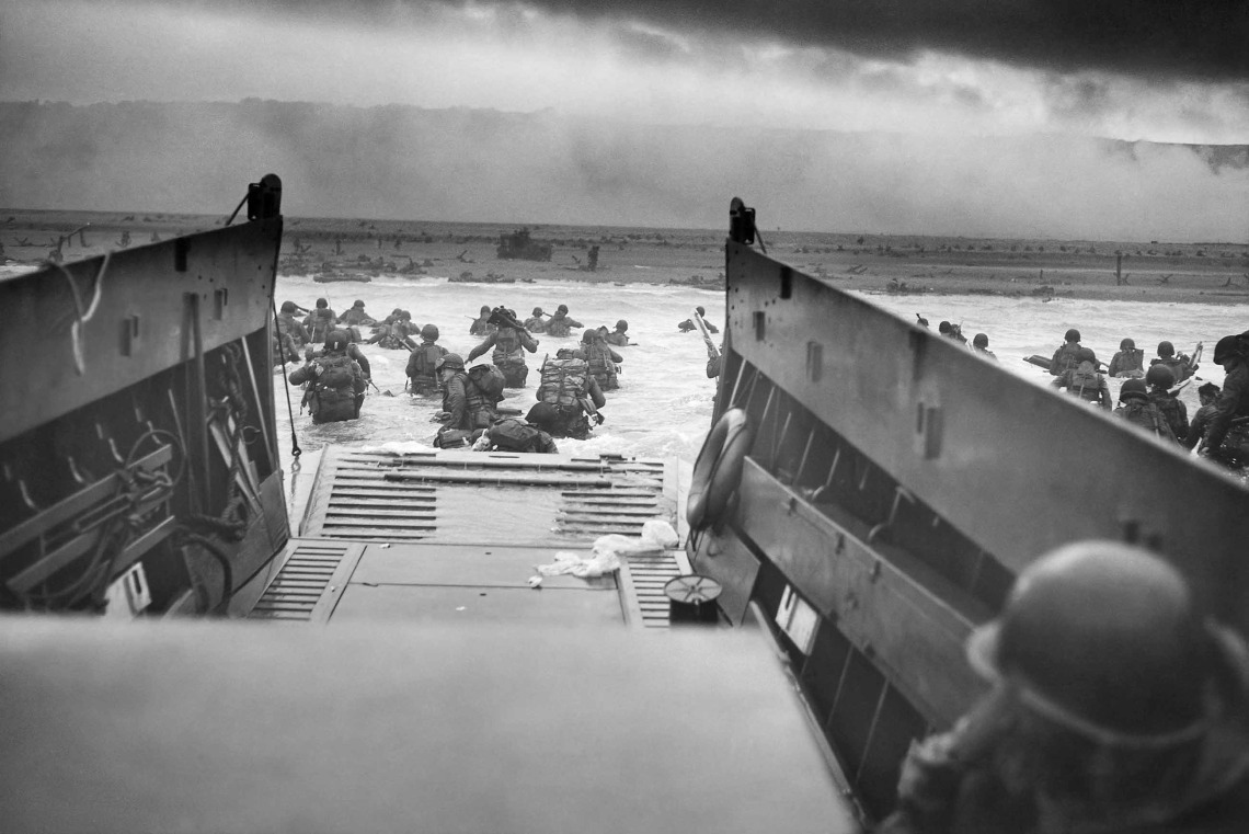 American troops wade ashore from a landing vehicle on Omaha Beach during the D-Day invasion on June 6, 1944.