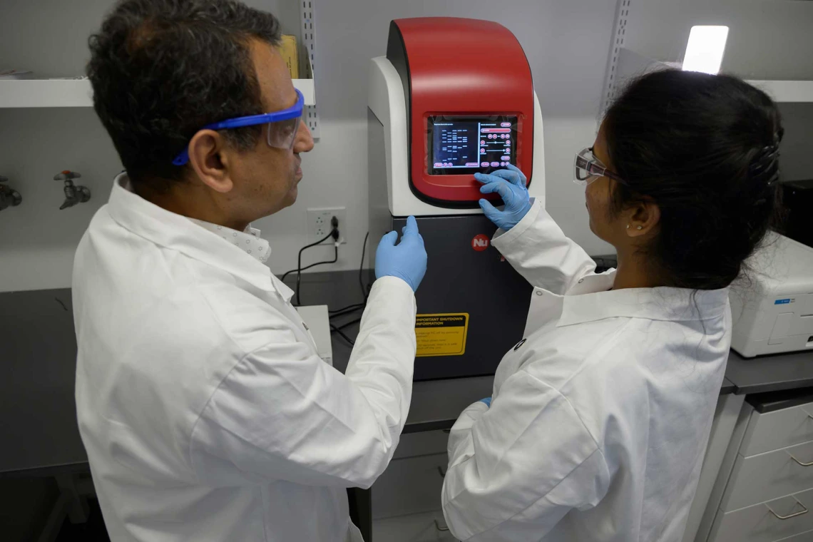 Researchers working with lab tech.