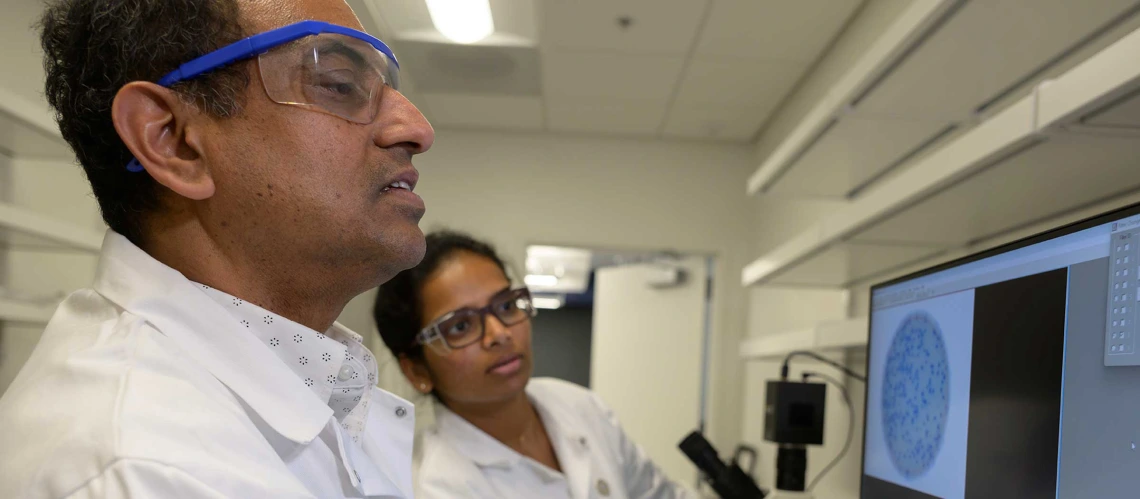 Researchers working with lab tech.