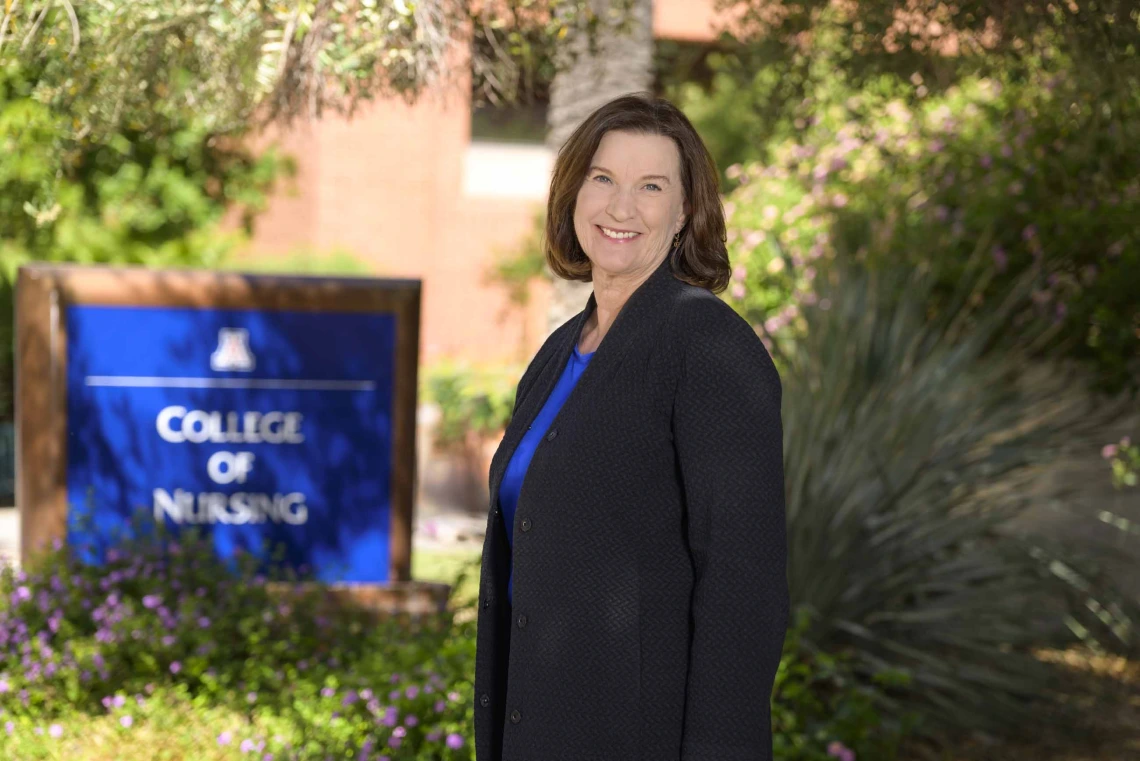 Terry A. Badger, PhD, RN, stands outside near the University of Arizona College of Nursing sign.