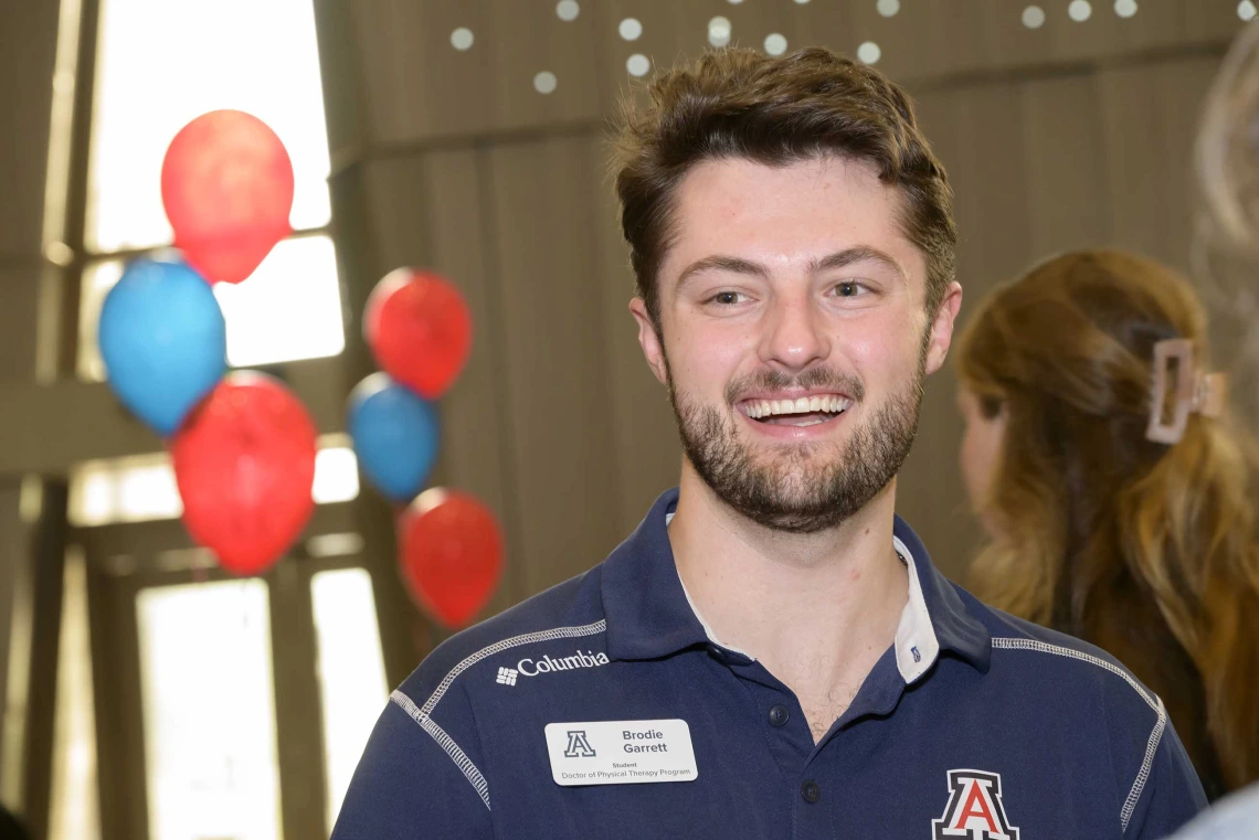Photo of student Brodie Garrett with red and blue balloons in the background.