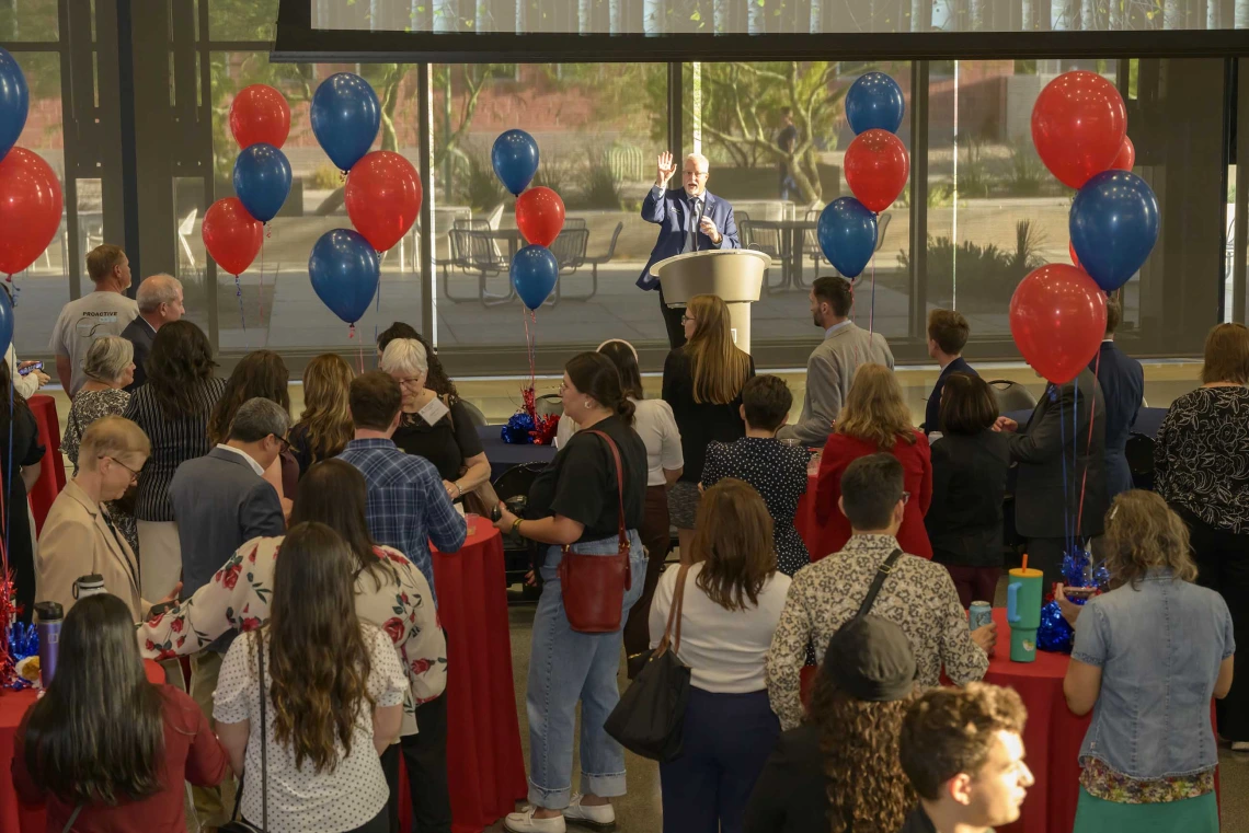 Photo of Kevin Lohenry at a podium as people look toward him. 