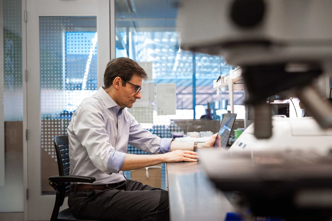 Stefano Guerra, MD, PhD, works with laptop in a lab