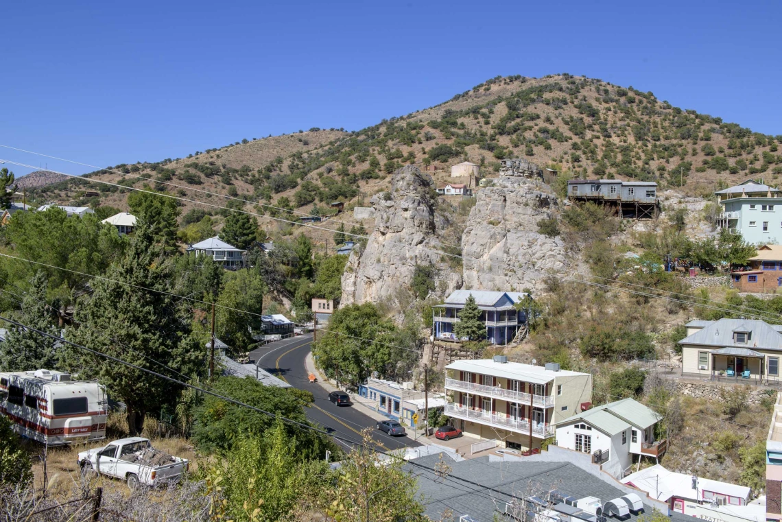 Aerial view of town of Bisbee, Arizona, showing main road, houses, hotel, store, with mountains in background