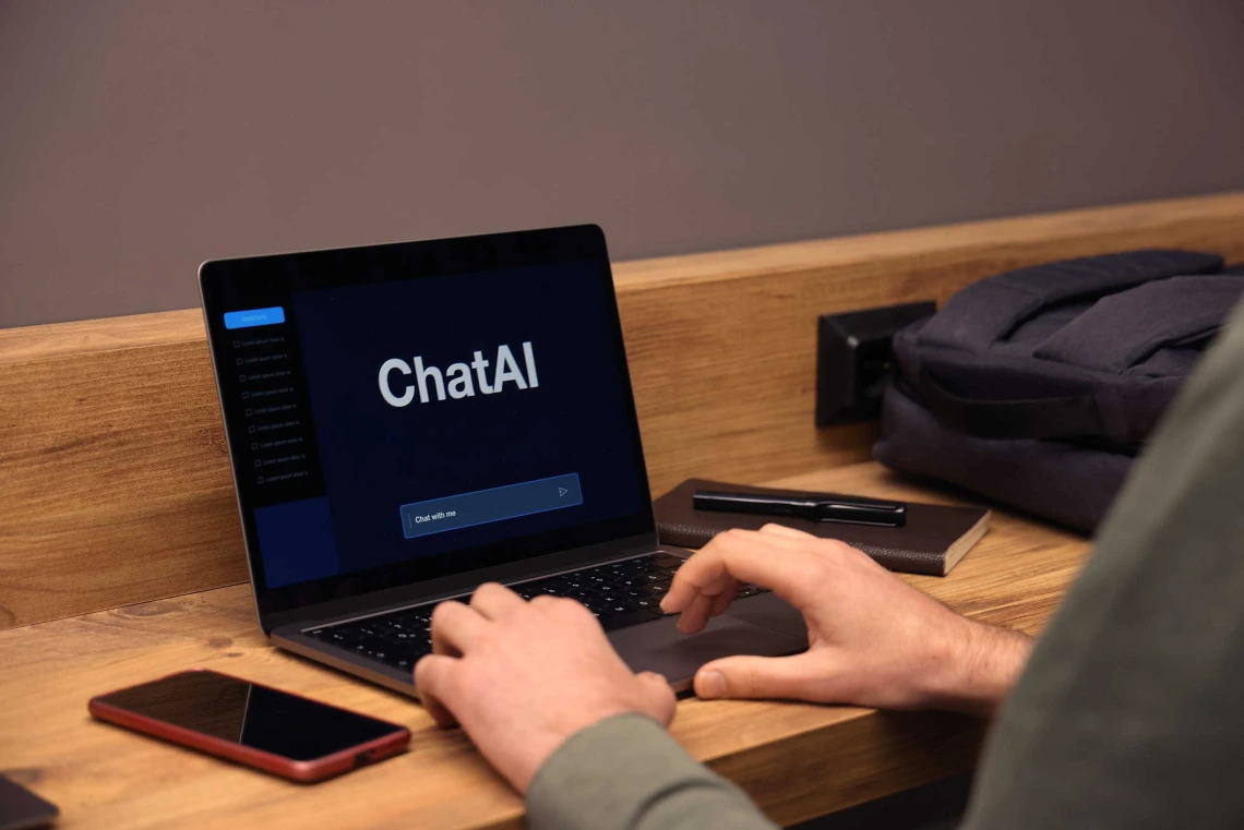 person using laptop with the words “ChatAI” on a black screen with a text prompt