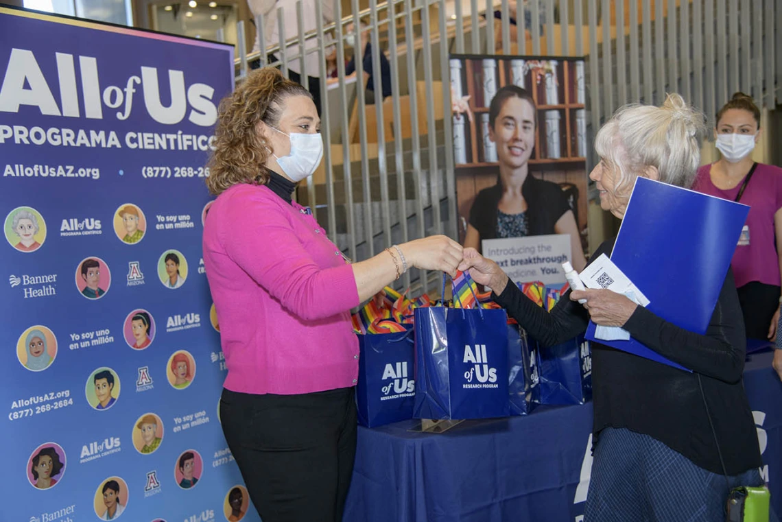 All of Us UArizona-Banner engagement coordinator, Erika Davila Rivas, welcomes Mary Douglas, an All of Us participant, at the 50k Strong Arizona Celebration and Research Showcase in the Health Sciences Innovation Building on the Tucson Campus.