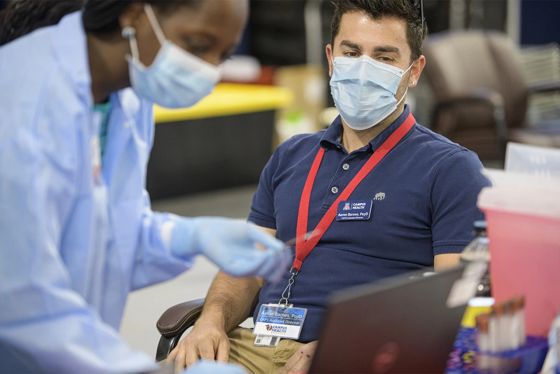 Among the essential workers receiving antibody tests, Aaron Barnes, PsyD CAPS Assistant Director of Campus Health. Barnes provides his name to health care worker before testing.