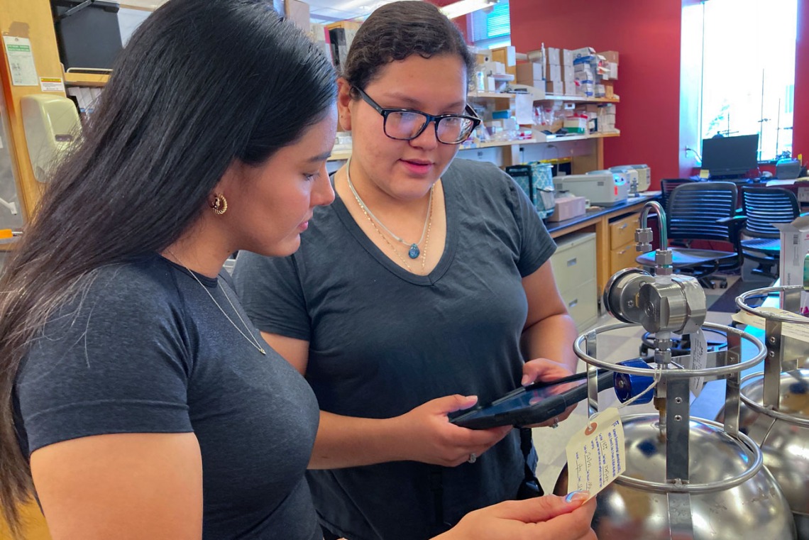 (from left) Fernanda Camargo, another FRONTERA participant, and Emma Gallardo Martinez examine Summa canisters used for air monitoring and sampling.