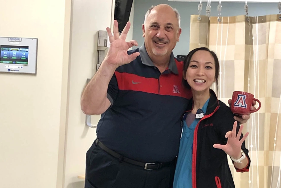 A man and woman pose for a camera in a hospital