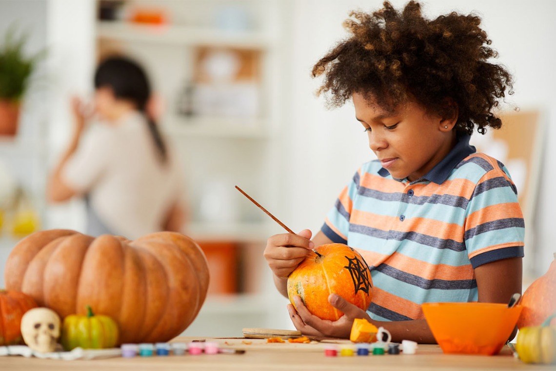 Kid painting a pumpkin 