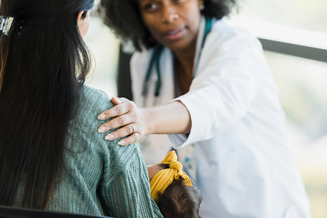 After giving her bad news, the mature adult female doctor consoles the unrecognizable new mom.