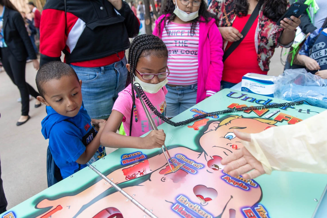 Children practice medical skills on life-sized Operation game sponsored by Phoenix Children's Hospital.