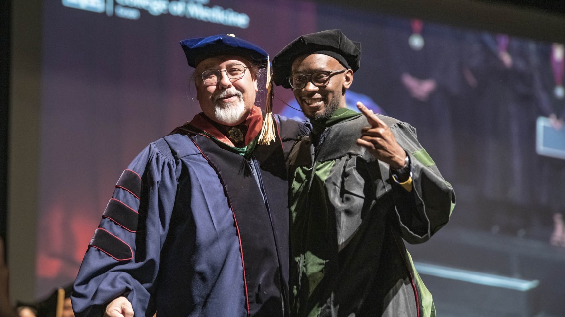 Assistant Dean of Curricular Affairs Carlos Gonzales, MD, congratulates Andrew Muse, MD, after hooding him during the College of Medicine – Tucson class of 2022 convocation at Centennial Hall.