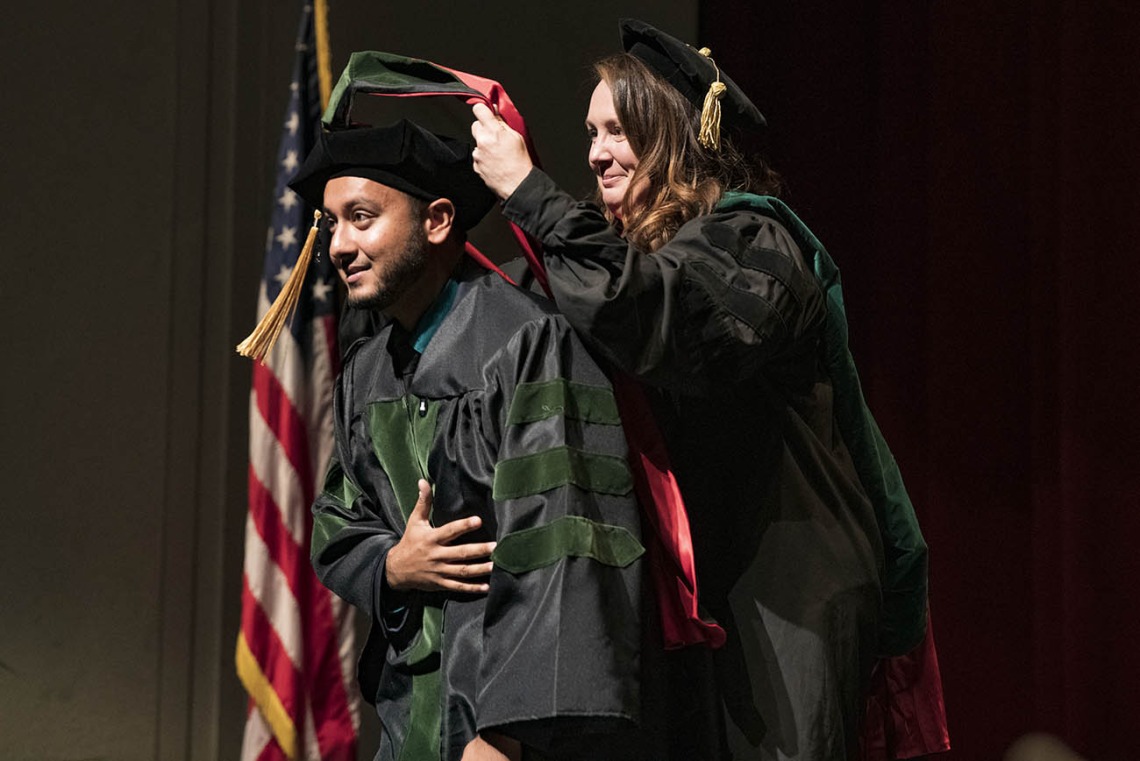 Professor Collene Cagno, MD, hoods Shirzad Shir, MD, during the College of Medicine – Tucson class of 2022 convocation at Centennial Hall.