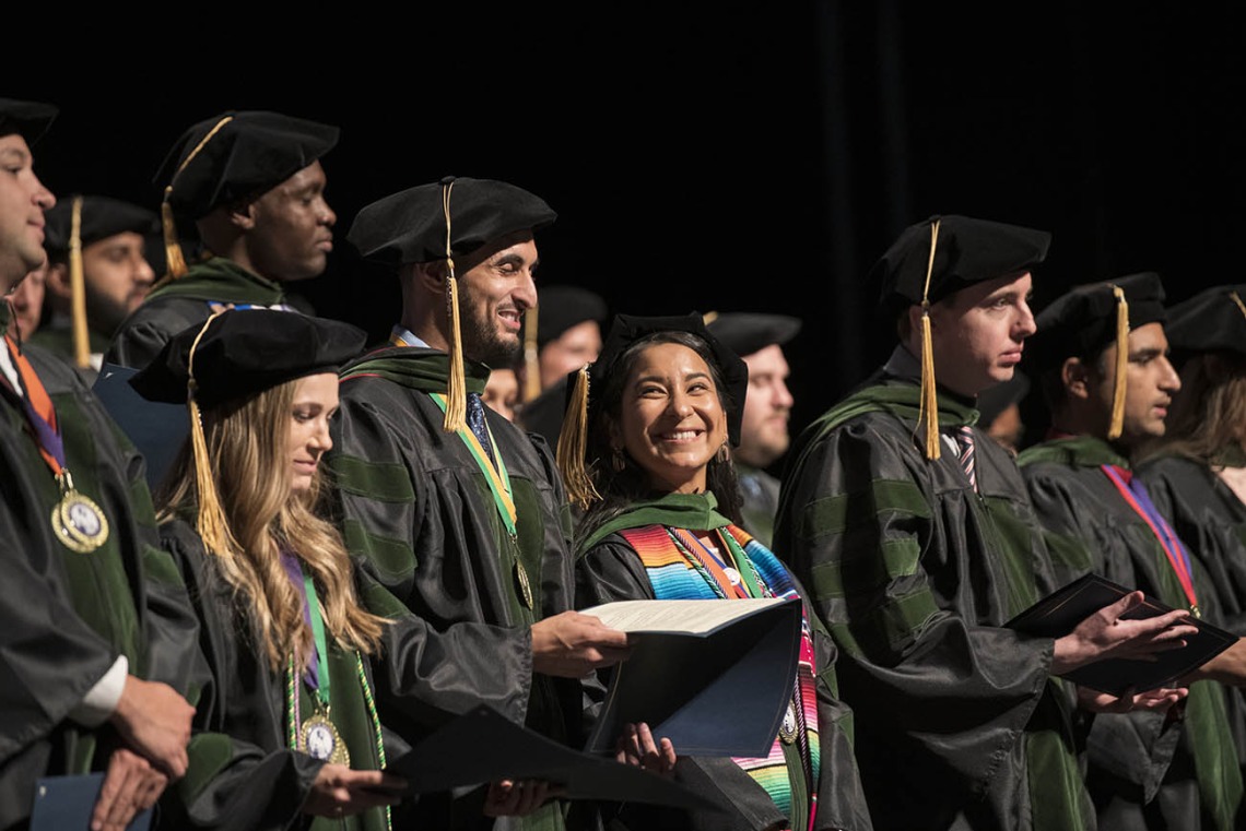 Naiby Rodriguez Zuniga, MD, (center smiling) can’t hide her excitement as she and her classmates prepare to recite the Hippocratic Oath at the end of their College of Medicine – Tucson class of 2022 convocation ceremony at Centennial Hall.