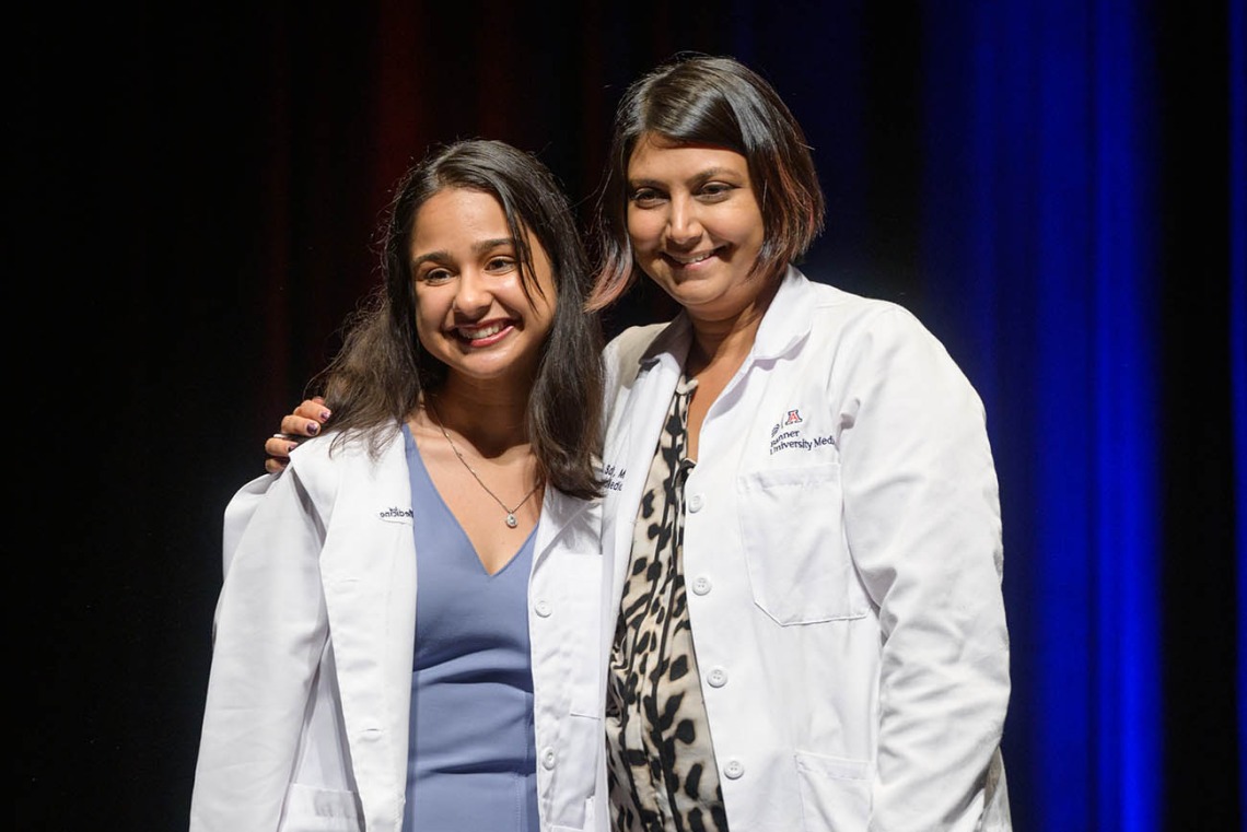 Nandini Sodhi pauses for a photo with Serena Scott, MD, assistant professor of medicine, during the UArizona College of Medicine – Tucson Class of 2026 white coat ceremony.