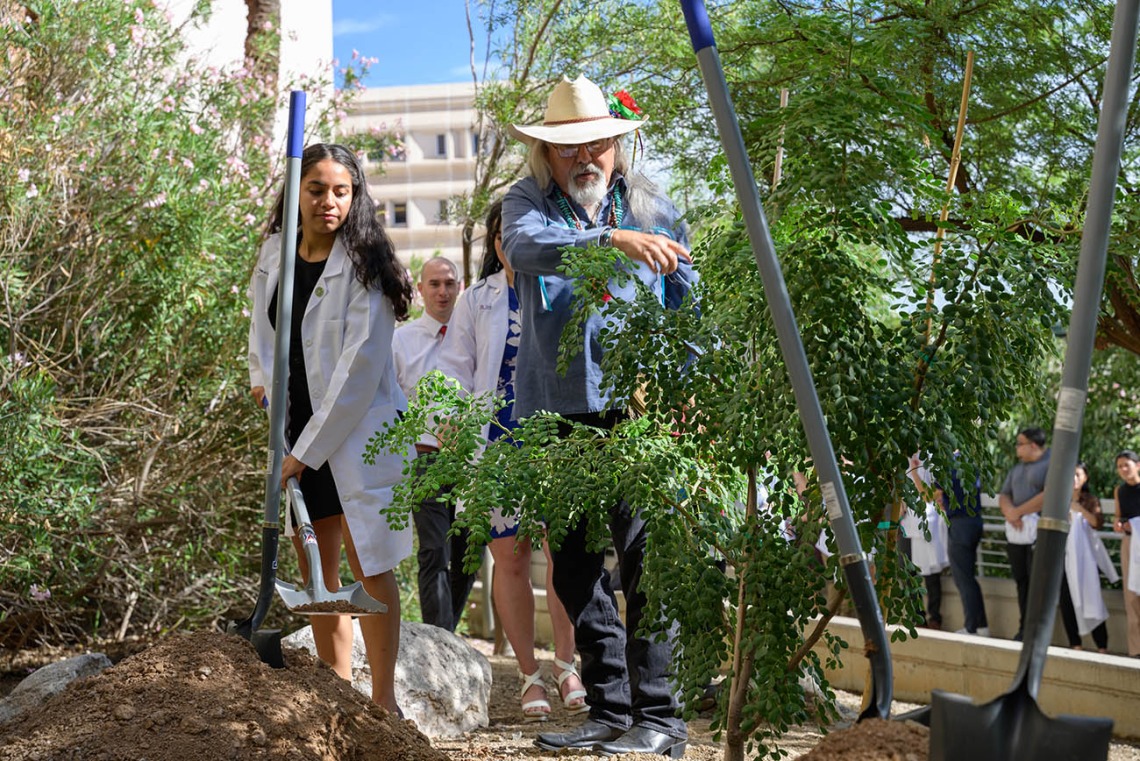 Medical students take turns shoveling dirt as they plant the tree honoring people who donated their bodies to science. Ashes from the sacred herbs are mixed in with the dirt of the newly planted tree.