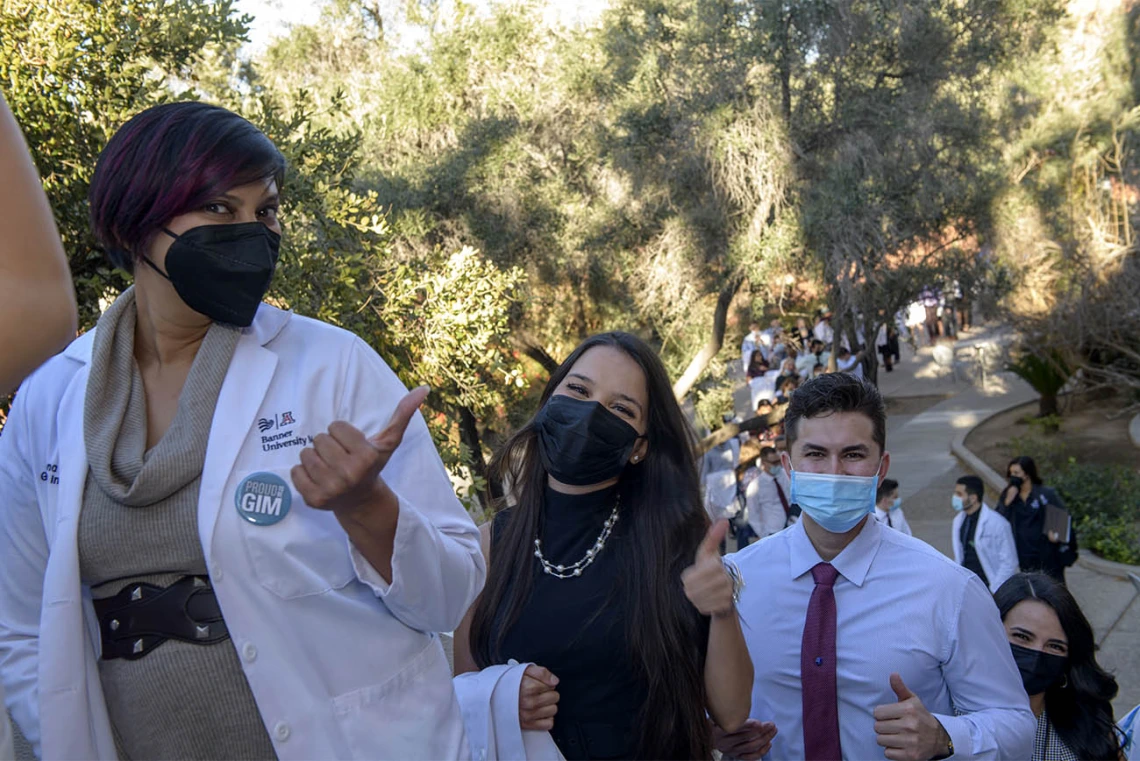 Serena Scott, MD, (left) and students Julia Alvarenga Fagundes Couto and Mark Bigbey wait in line before the class of 2024 white coat ceremony begins at UArizona Student Union Main Ballroom.