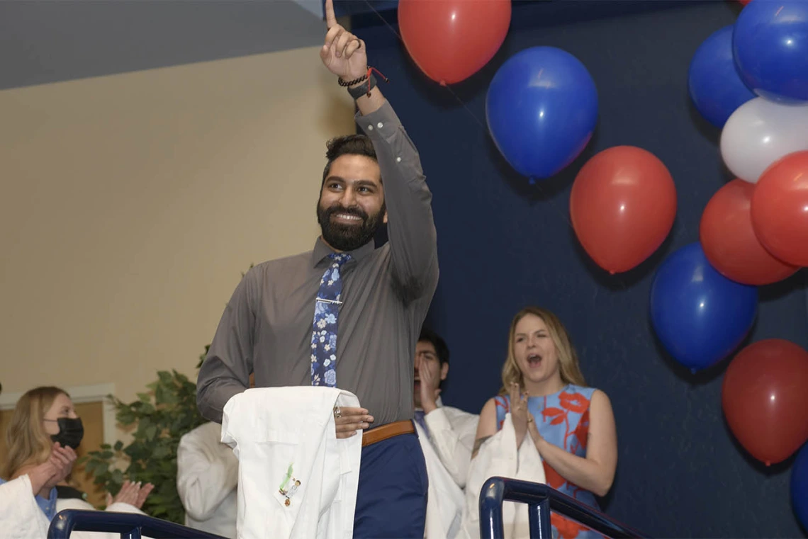 Mihir Shah celebrates as he walks onto the stage during the UArizona College of Medicine – Tucson’s class of 2024 white coat ceremony. 