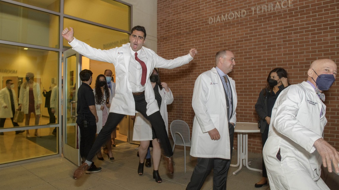 Even gravity can’t hold back the excitement David Ahmadian feels as he and his fellow class of 2024 College of Medicine – Tucson students emerge from their twice-postponed white coat ceremony in late February.  