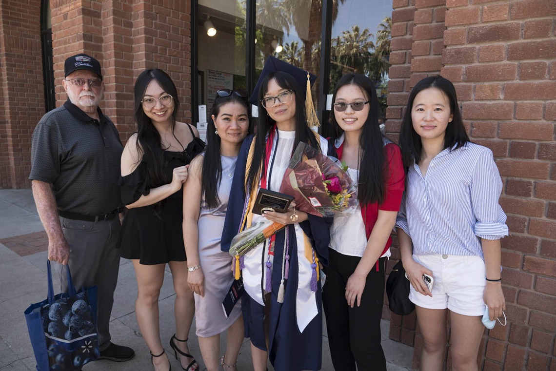 Lina Thai, who earned her Bachelor of Science in Nursing, stands with her family after the UArizona College of Nursing 2022 spring convocation at Centennial Hall.