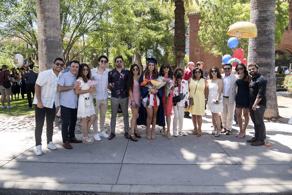 Bareen Rafiq poses for a photo with her family outside Centennial Hall after being awarded a Bachelor of Science in Nursing at the UArizona College of Nursing 2022 spring convocation.