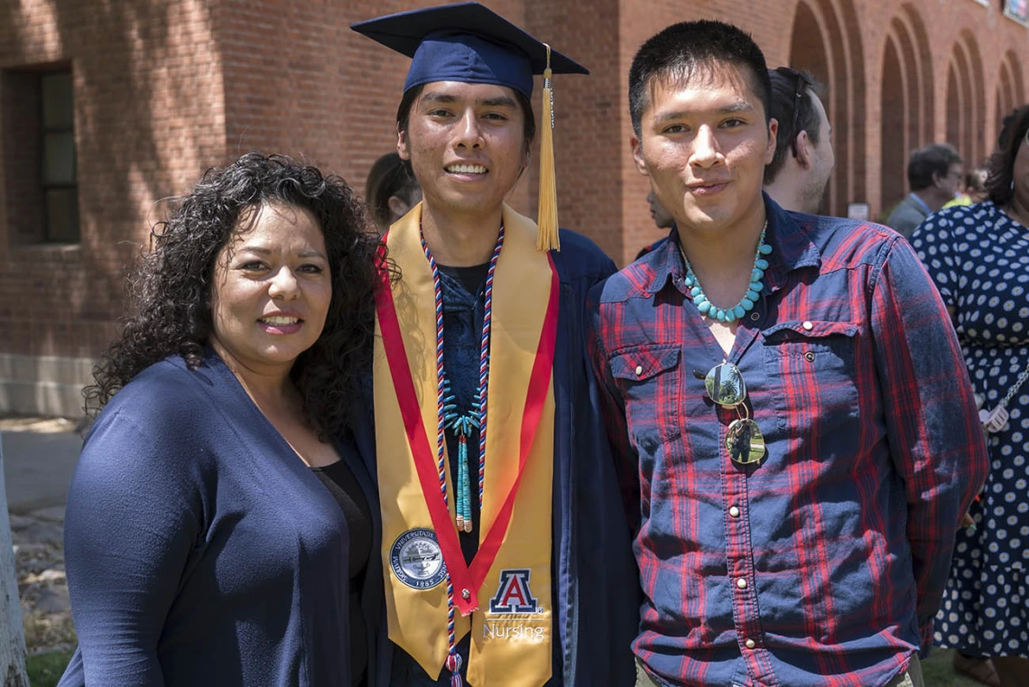 Lydia Parra (left), coordinator for the UArizona College of Nursing’s ANIE Program, takes a photo with Bachelor of Science in Nursing graduate Joshua Billy and his brother, Justin Billy after the College of Nursing 2022 spring convocation at Centennial Hall.