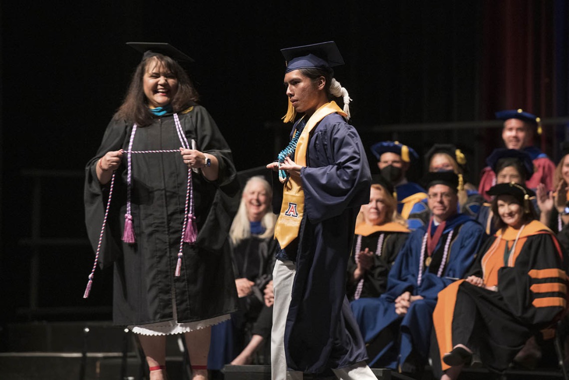 Linda Perez, MHA, RN, prepares to give a cord to Joshua Billy during the UArizona College of Nursing 2022 spring convocation at Centennial Hall.