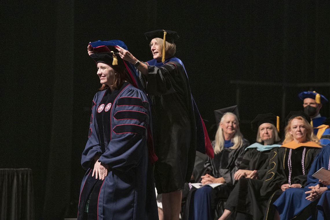 Stacy Al-Saleh, PhD, is hooded by Kathie Insel, PhD, RN, for earning her Doctor of Philosophy in Nursing during the UArizona College of Nursing 2022 spring convocation at Centennial Hall. 