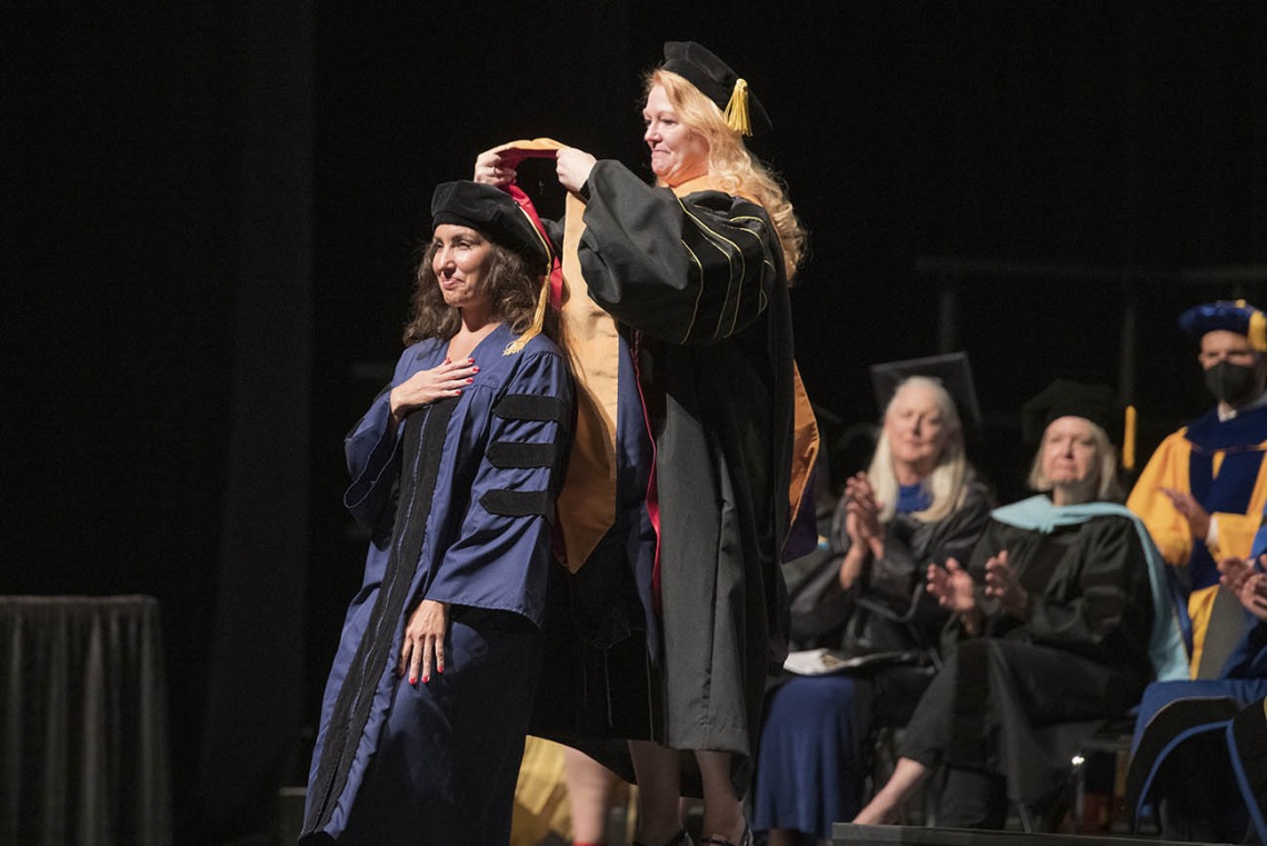 Elizabeth Partida, DNP, is hooded by Kristie Hoch, DNP, CRNA, MS, RRT, for earning her Doctor of Nursing Practice during the UArizona College of Nursing 2022 spring convocation at Centennial Hall.