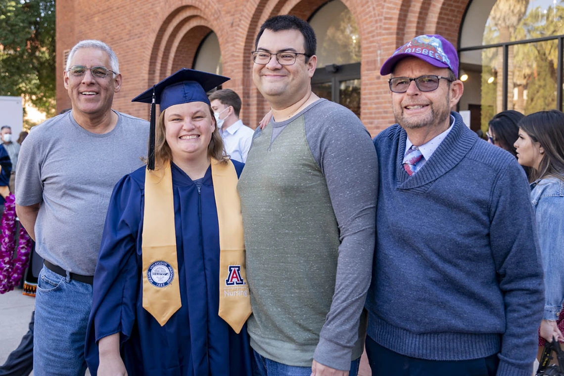 College of Nursing student Elizabeth Dueñes poses for a family photo with her father-in-law, Steve Dueñes (left), her husband Michael Dueñes (center) and her father Jim King at the fall convocation at Centennial Hall.