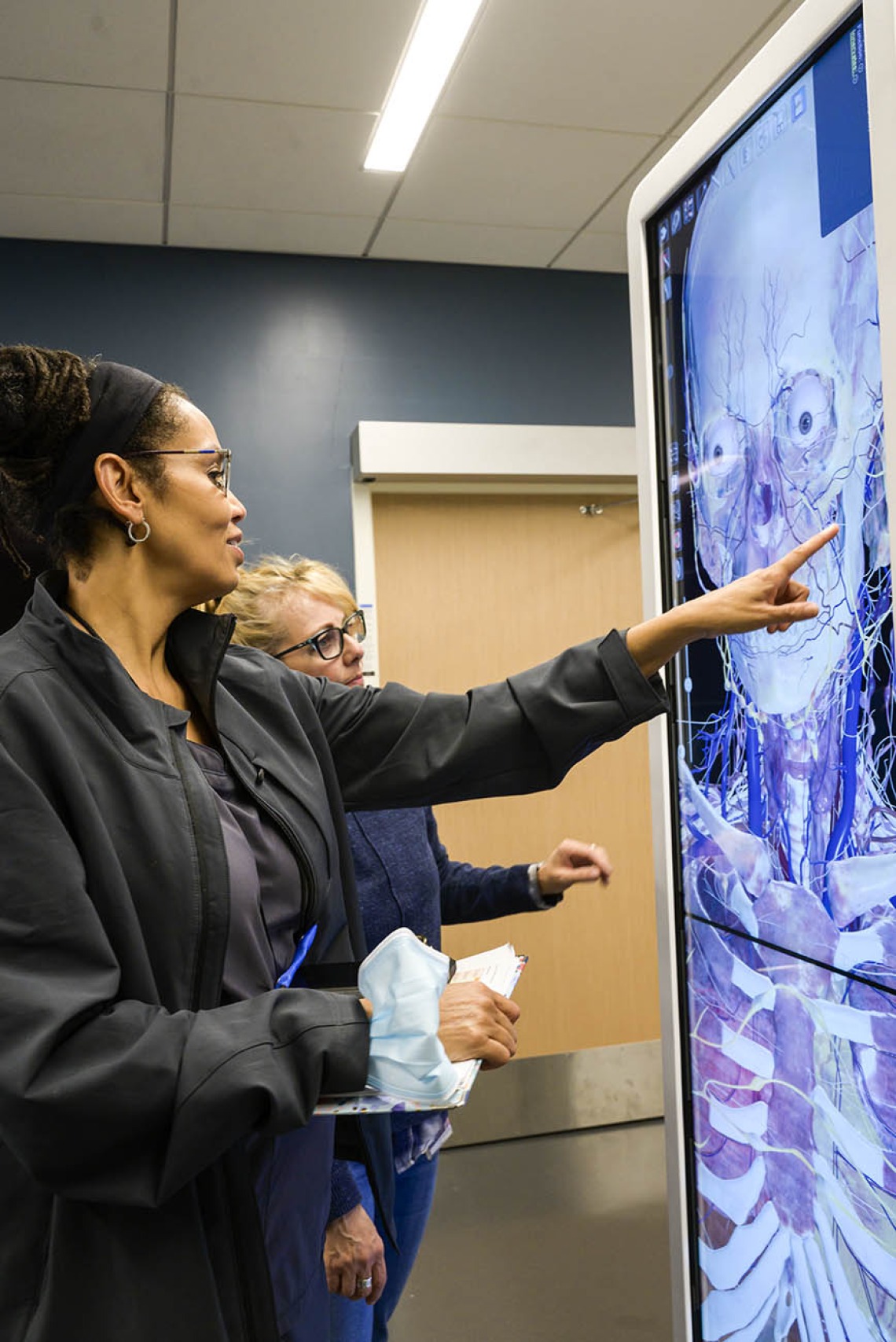 A UArizona Colllege of Nursing professor reviews the anatomage table with a simulation educator.