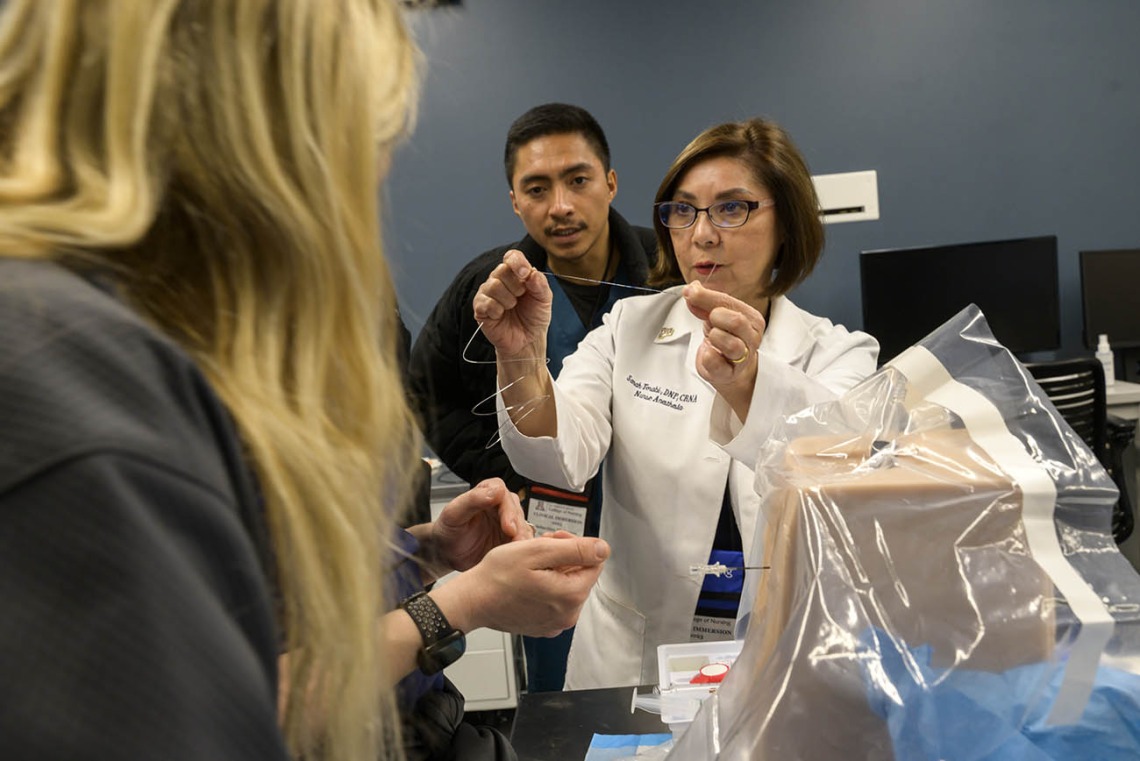 UArizona College of Nursing professor reviews the instruments needed for a spinal tap with Doctor of Nursing Practice students during a clinical immersion session. 
